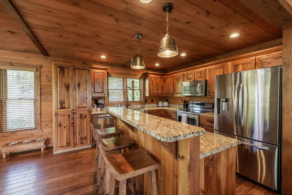 Above the Clouds cabin fully equipped kitchen with granite island and stainless steel appliances in Blue Ridge Georgia