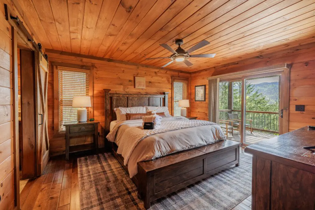 Above the Clouds cabin master bedroom with king bed barn door and private deck mountain view in Blue Ridge Georgia