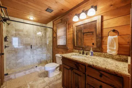 Above the Clouds cabin en suite bathroom with travertine walk-in shower and granite vanity in Blue Ridge Georgia