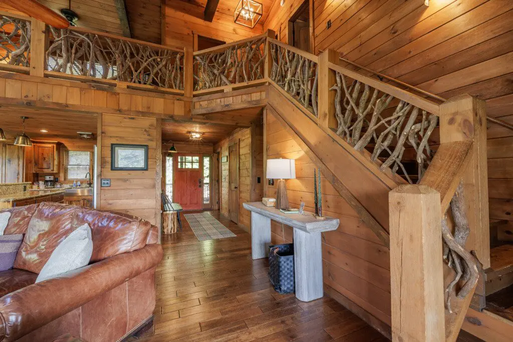 Above the Clouds cabin open floor plan with handcrafted antler branch staircase and loft in Blue Ridge Georgia
