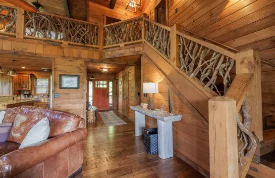 Above the Clouds cabin open floor plan with handcrafted antler branch staircase and loft in Blue Ridge Georgia