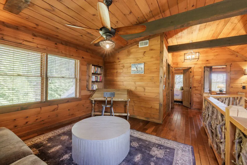Above the Clouds cabin loft second angle with hallway to upper bedroom and antler railing in Blue Ridge Georgia