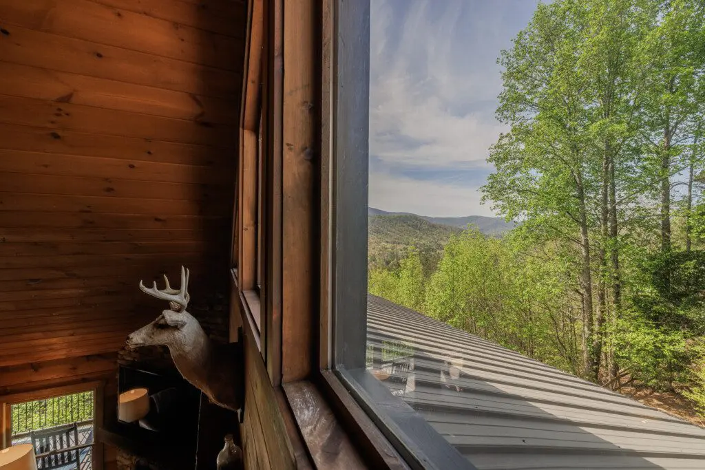 Above the Clouds cabin loft window view of North Georgia mountain ridgeline and treetops in Blue Ridge Georgia