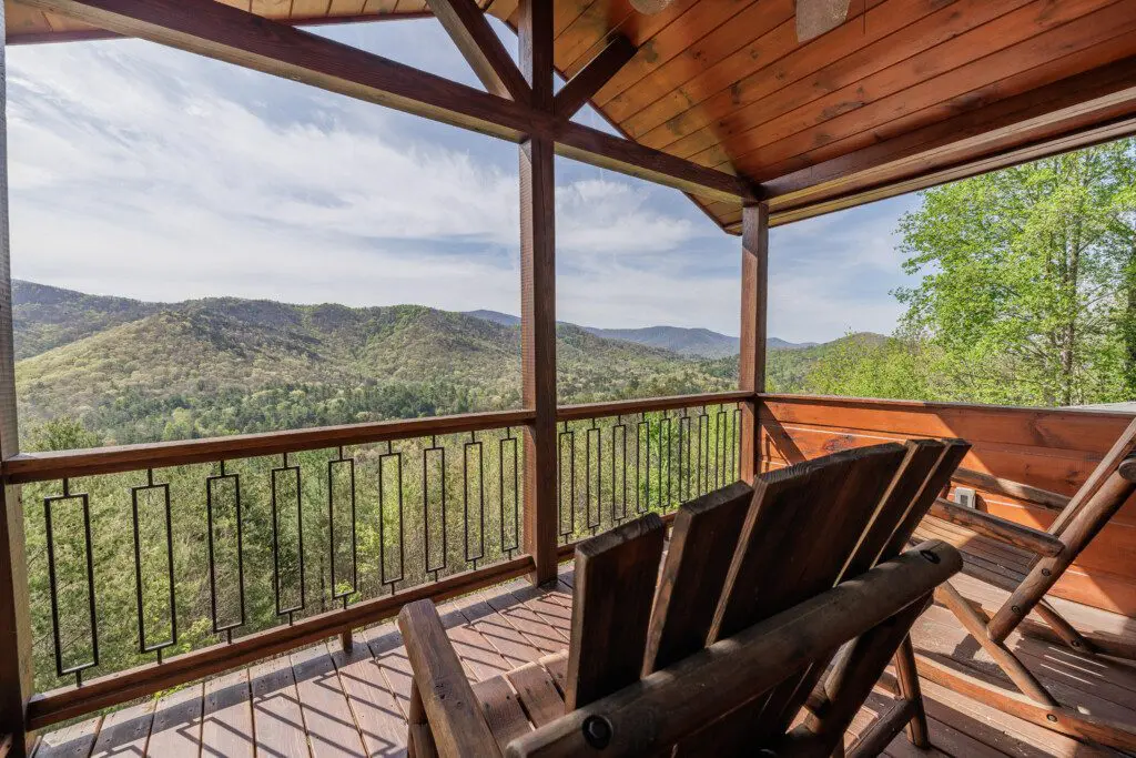 Above the Clouds cabin deck Adirondack chairs with layered North Georgia mountain views in Blue Ridge Georgia