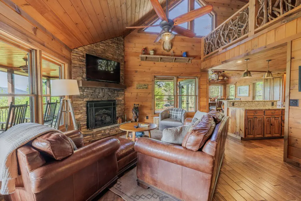 Above the Clouds cabin open living room with stone fireplace and vaulted cedar ceiling in Blue Ridge Georgia