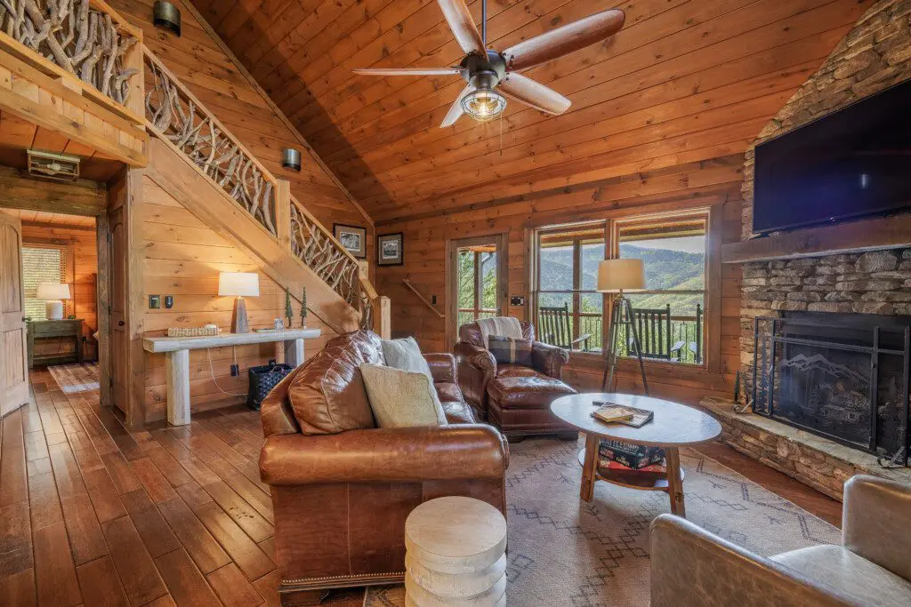 Above the Clouds cabin living room with antler staircase railing and mountain views in Blue Ridge Georgia