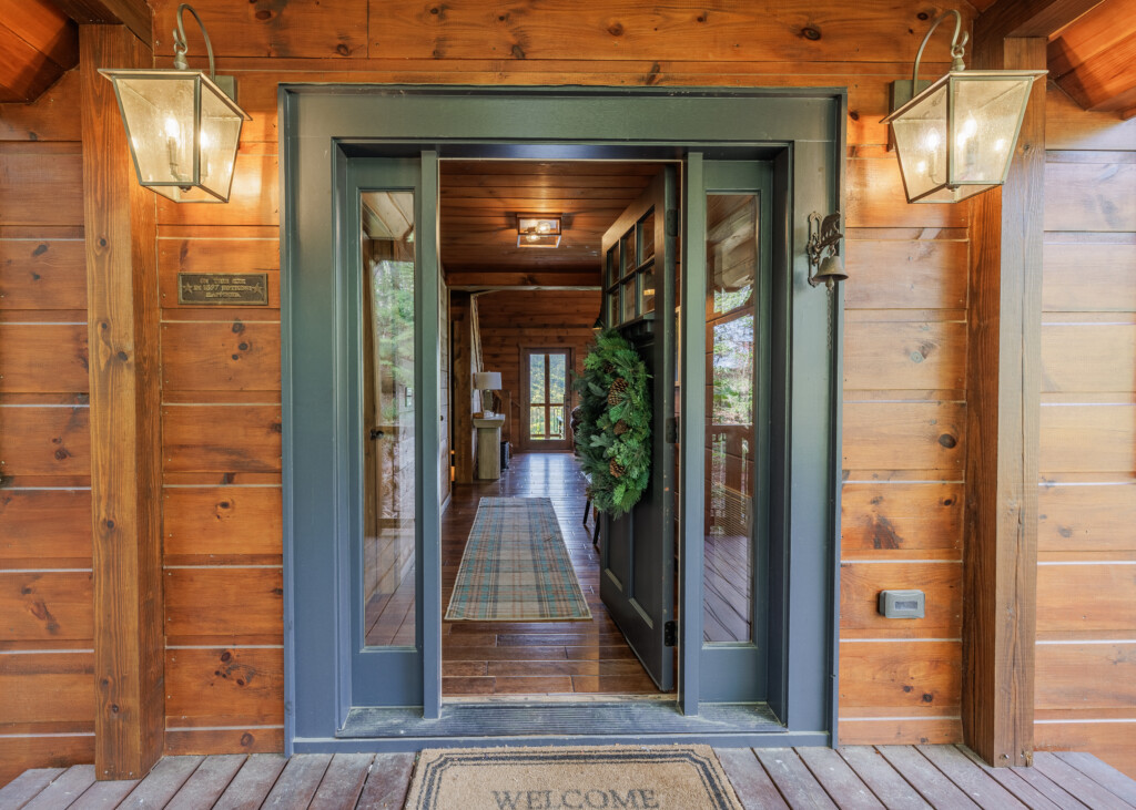 Above the Clouds cabin front entrance with sage green door and lantern lighting in Blue Ridge Georgia