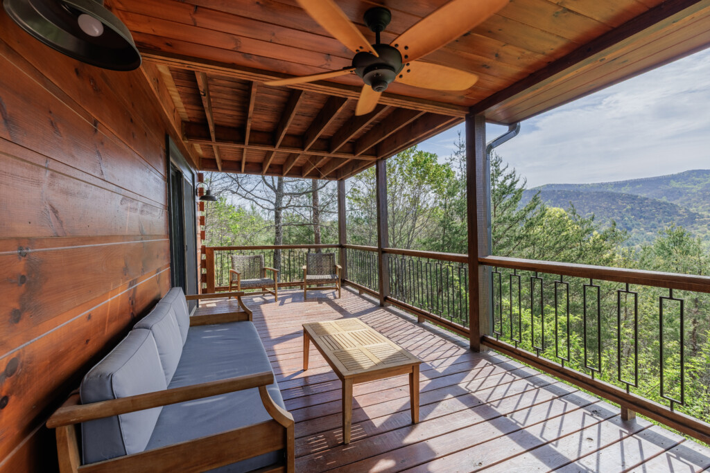 Above the Clouds cabin covered outdoor deck with sectional seating and mountain views in Blue Ridge Georgia