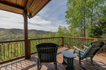 Above the Clouds cabin open deck with Adirondack chairs and layered mountain views in Blue Ridge Georgia