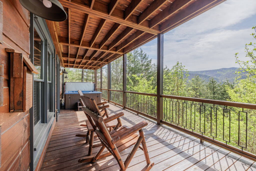 Above the Clouds cabin deck with hot tub and log rocking chairs overlooking North Georgia mountains in Blue Ridge Georgia