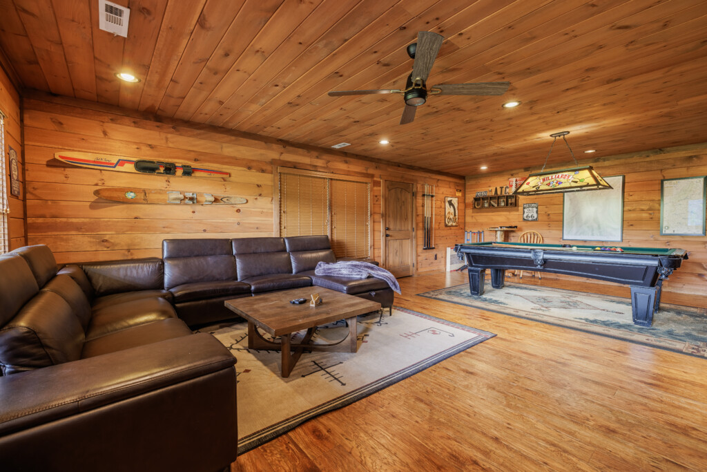 Above the Clouds cabin game room with pool table and leather sectional in Blue Ridge Georgia