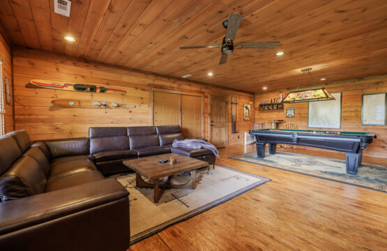Above the Clouds cabin game room with pool table and leather sectional in Blue Ridge Georgia