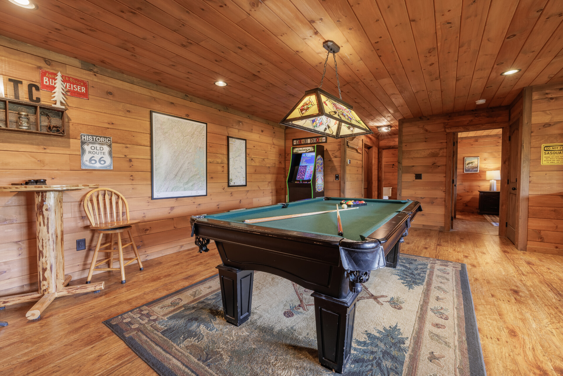 Above the Clouds cabin game room pool table and arcade machine with vintage decor in Blue Ridge Georgia
